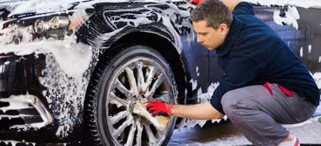 hombre lavando las llantas de un coche en un car wash