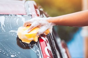 mano lavando el vidrio de un coche en un car wash